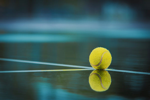 Tennisball liegt am Belag